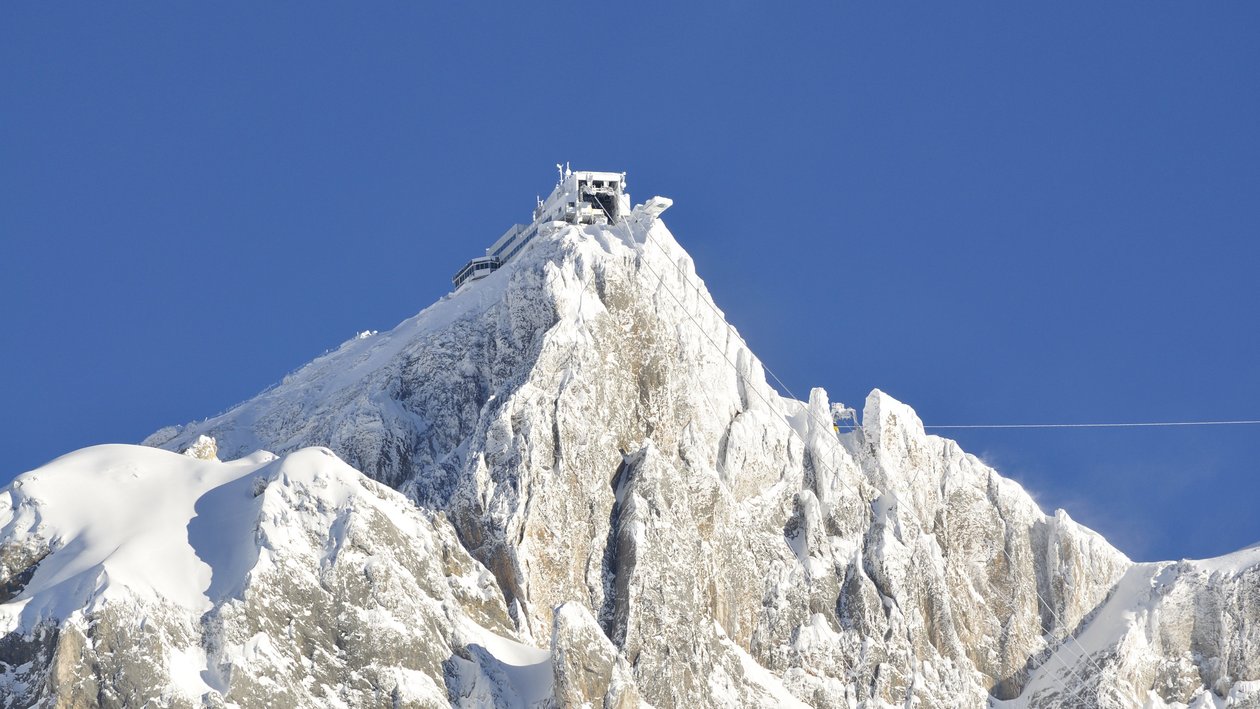 Alpine Schönheit am Hunerkogel Schneebedeckter Berggipfel mit Gebäude und Seilbahn in der Alpenlandschaft bei Ramsau