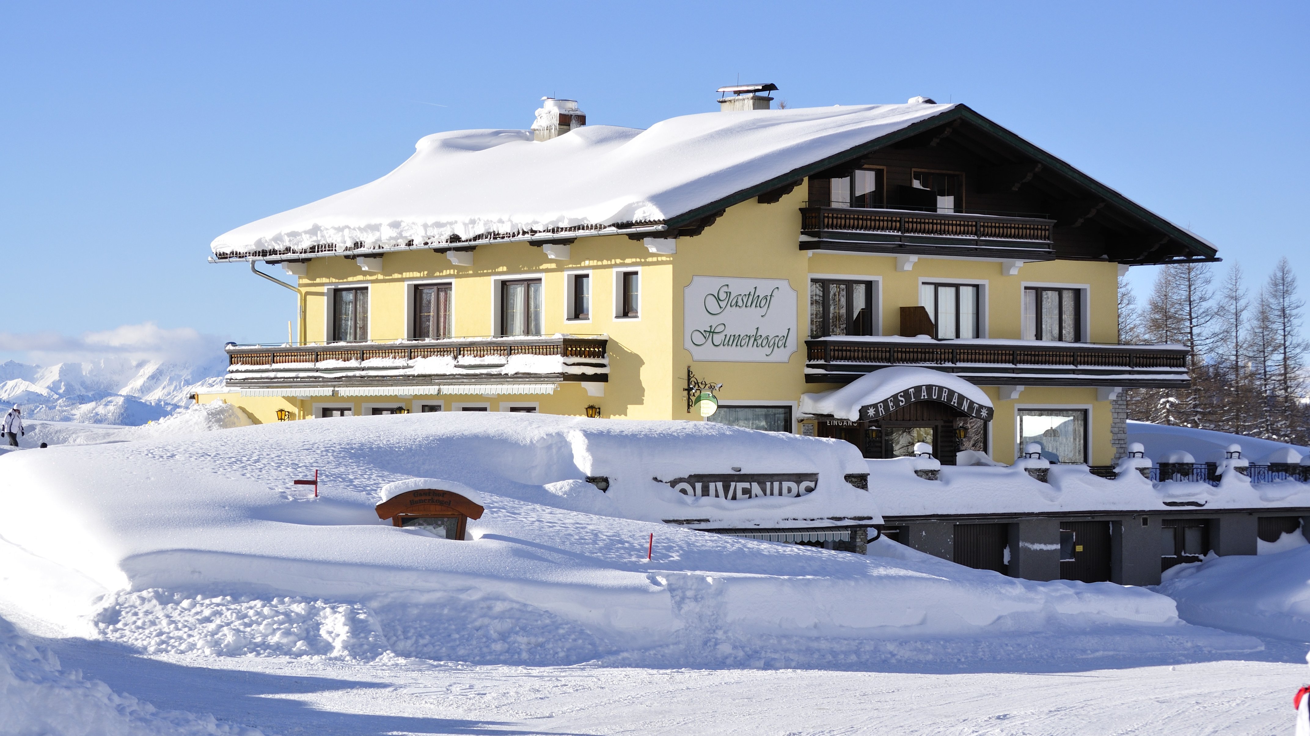 Alpenlodge im Wintertraum Schneebedecktes Gebäude im alpinen Stil in einer winterlichen Landschaft mit Bergen.