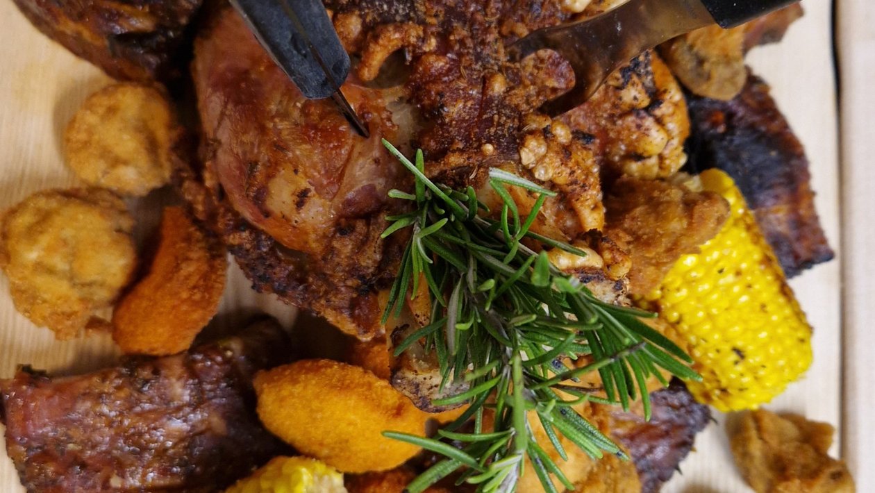 Bunte Auswahl an gegrilltem Essen mit Meeresfrüchten und Gemüsebeilagen auf einem Teller