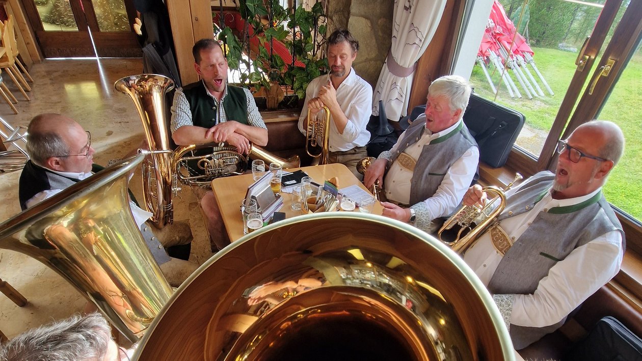 Traditionelle Blasmusik in gemütlicher Atmosphäre Gruppe von Musikern in traditioneller Kleidung, die Blechblasinstrumente spielt.