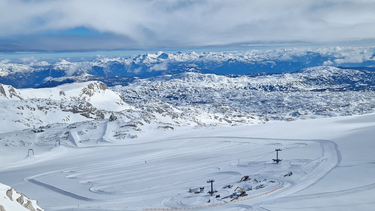 Winterliche Berglandschaft im Skigebiet Schneebedeckte Berge mit Skiliften und präparierten Pisten im Hintergrund der Szene.