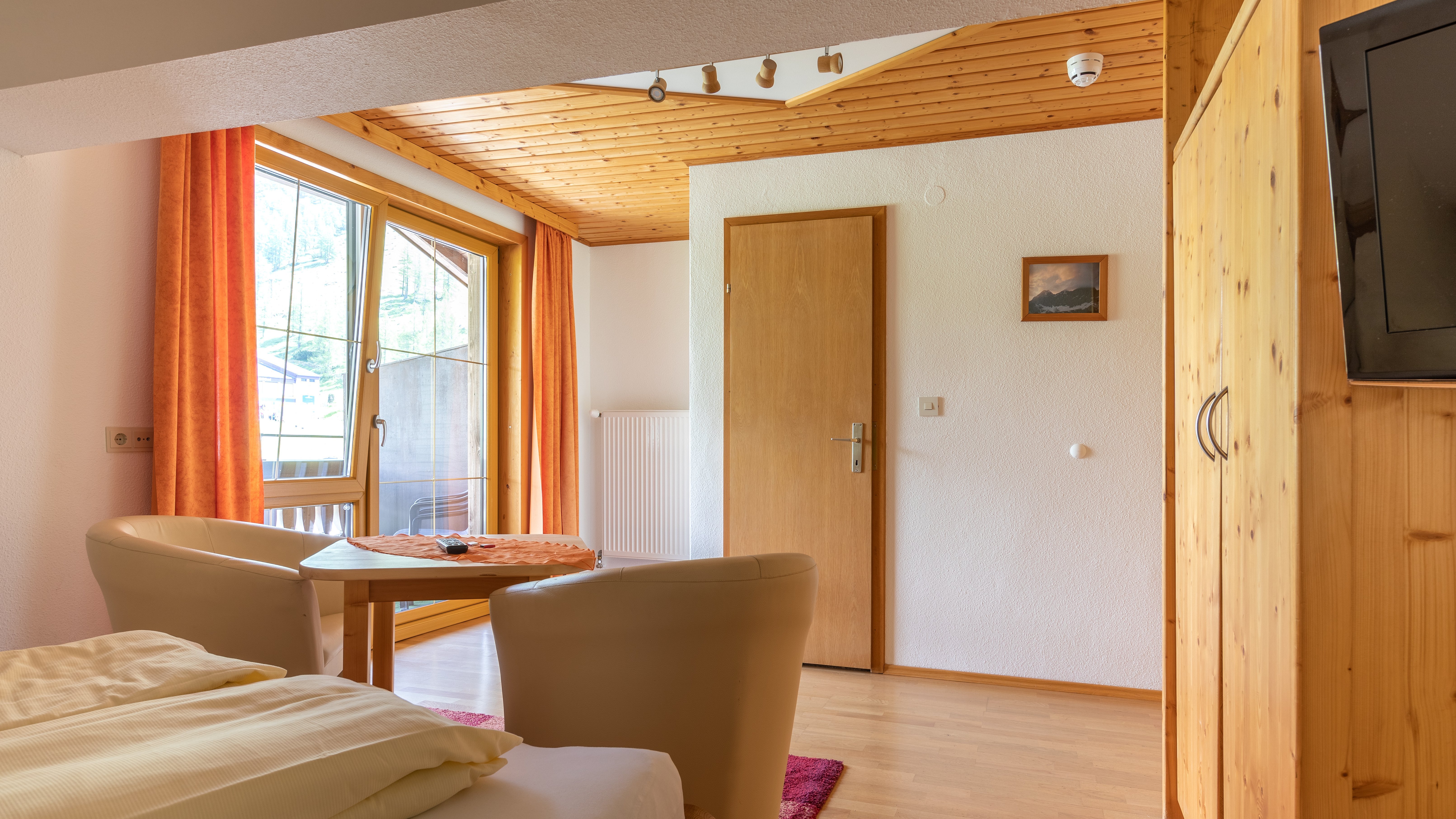 Hotelzimmer mit Holz Möbeln, großem Fenster und gemütlicher Atmosphäre im Innenraum