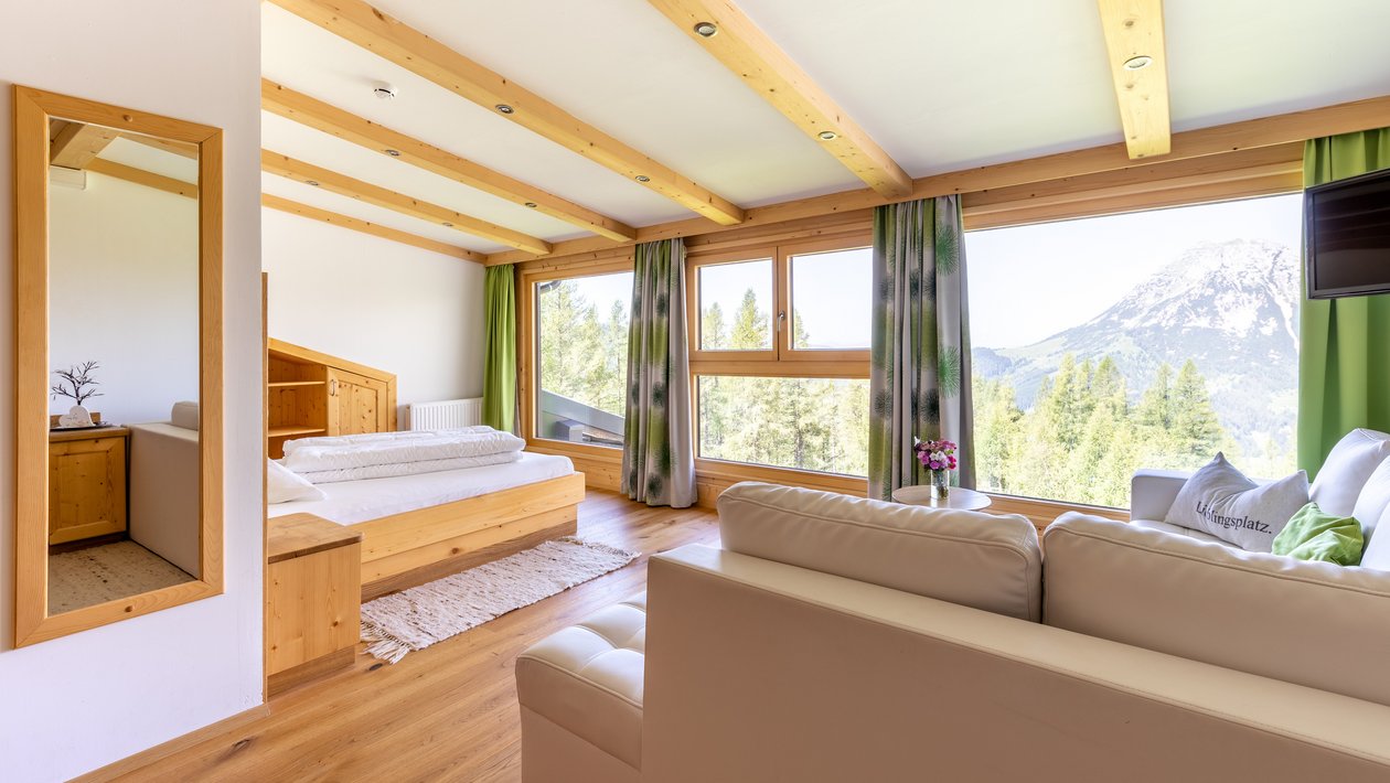 Moderne Wohnatmosphäre mit Bergblick Heller, moderner Wohnraum mit Holzdecke und großen Fenstern, die auf Berge blicken