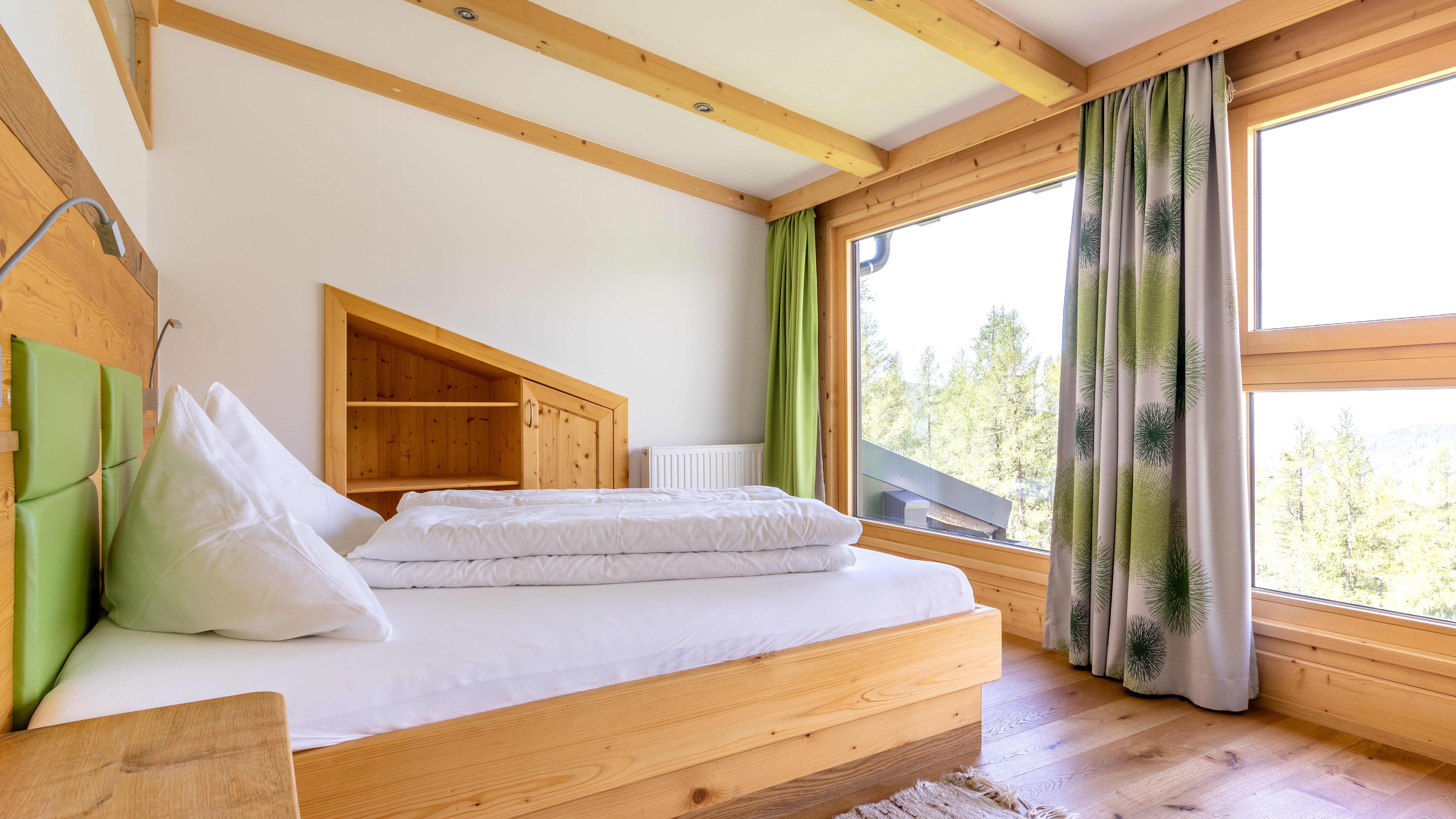Helles modernes Schlafzimmer mit Holzmöbeln und großen Fenstern zur Natur draußen