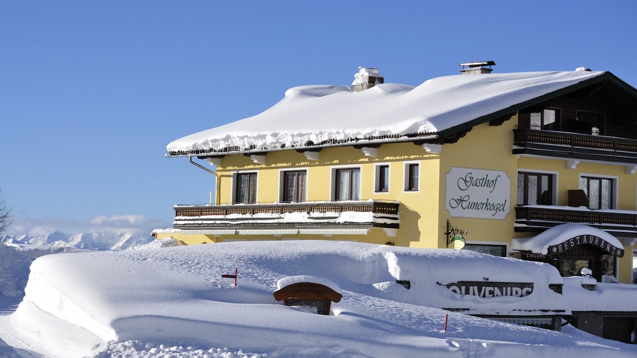 Idyllische Winterlandschaft am Berggasthof Berggasthof im verschneiten Landschaftsbild mit klarem Himmel im Hintergrund auf einem Berg