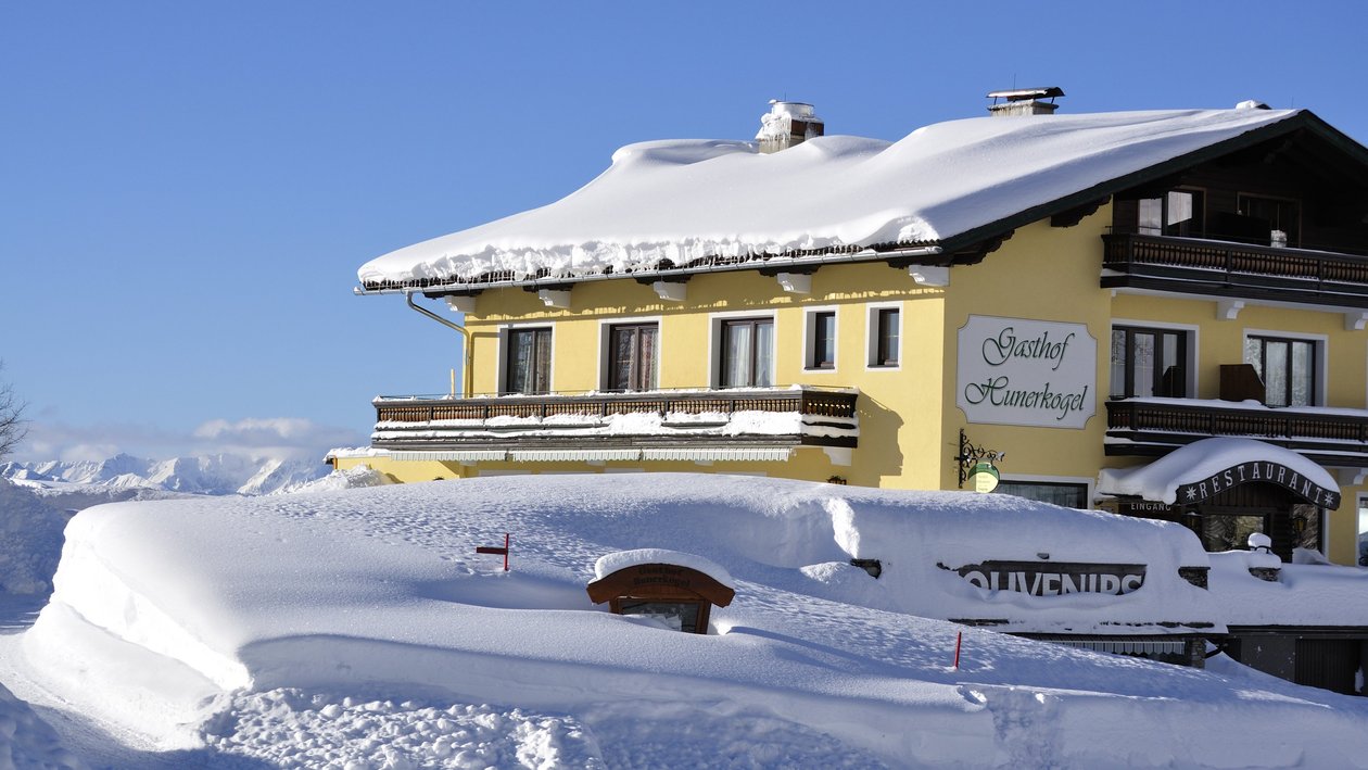 Idyllische Winterlandschaft am Berggasthof Berggasthof im verschneiten Landschaftsbild mit klarem Himmel im Hintergrund auf einem Berg